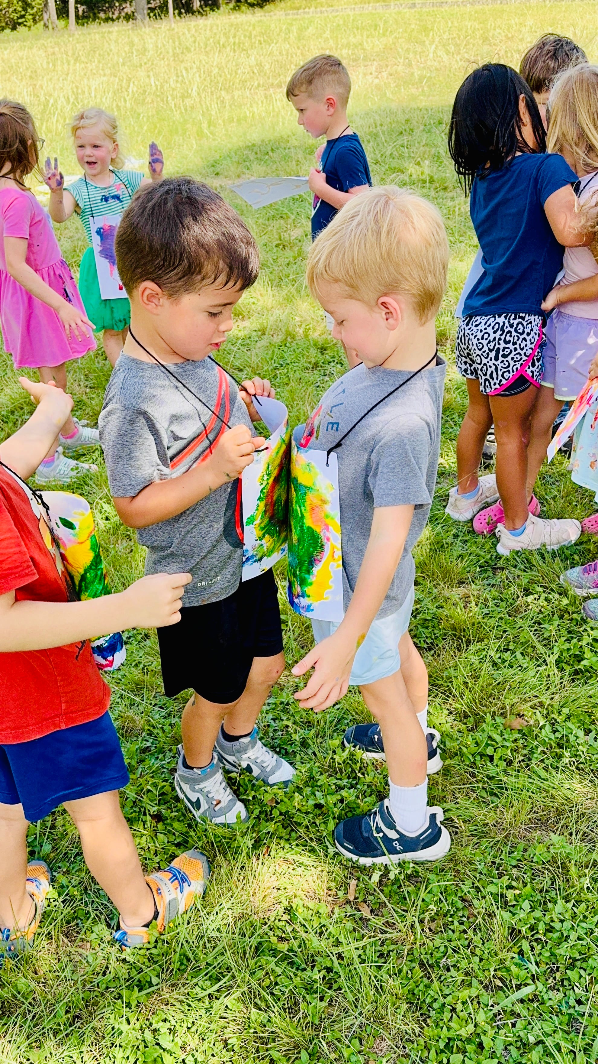 Preschool children doing art with friends at camp.