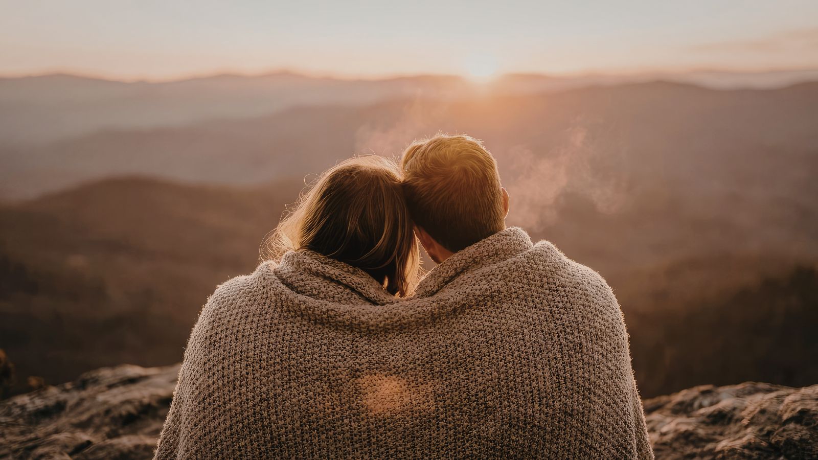 casal enconstado ao nascer do sol