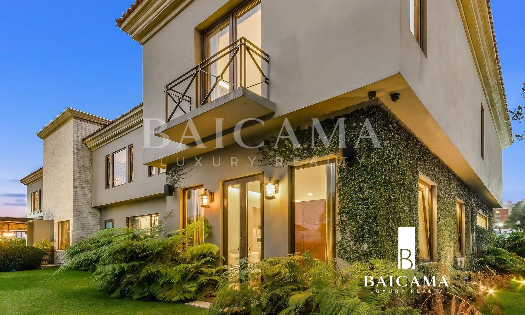 Fachada exterior de casa contemporánea en Fuentes de las Lomas (Interlomas), CDMX, de dos niveles al atardecer, con muros claros, balcones con barandal metálico, grandes ventanales iluminados, jardín con helechos y vegetación perimetral; diseño elegante y residencial en entorno verde.