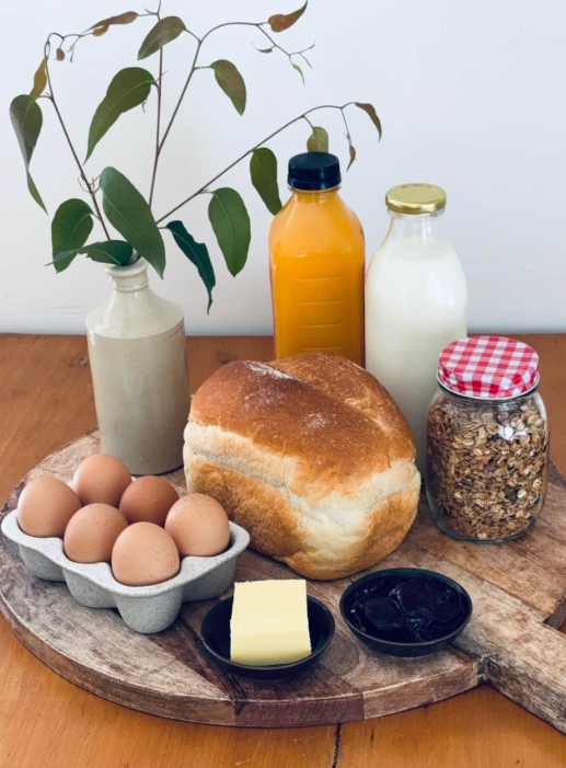 breakfast hamper with eggs fresh bread orange juice home made granola full cream milk butter and jam