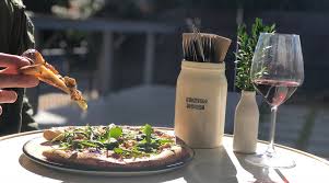 Casual dining at Station House Pizza with outdoor seating and handcrafted pizzas near Andersons Eco Retreat