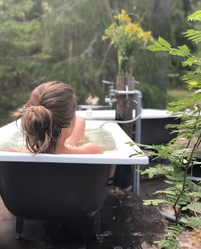 Woman enjoying a private outdoor bath in the forest at Tubs in the Scrub, Gembrook, VIC