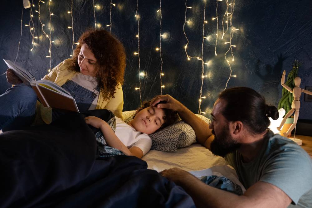 Padres leyendo un cuento infantil a su hijo antes de dormir, en una habitación iluminada con luces cálidas, momento familiar de lectura nocturna
