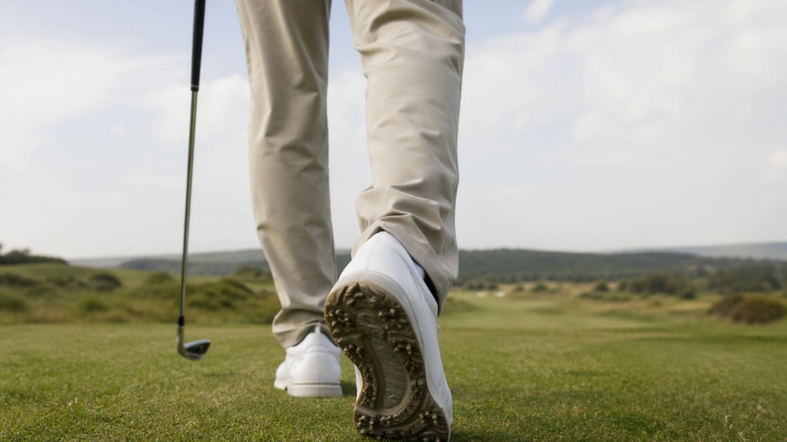 Older golfer walking in golf shoes on the course