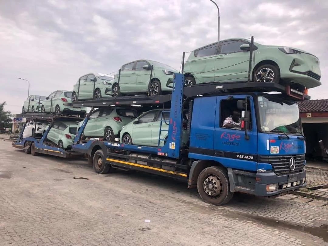 Double loader truck with 2 vehicles loaded and 2 members of staff observing