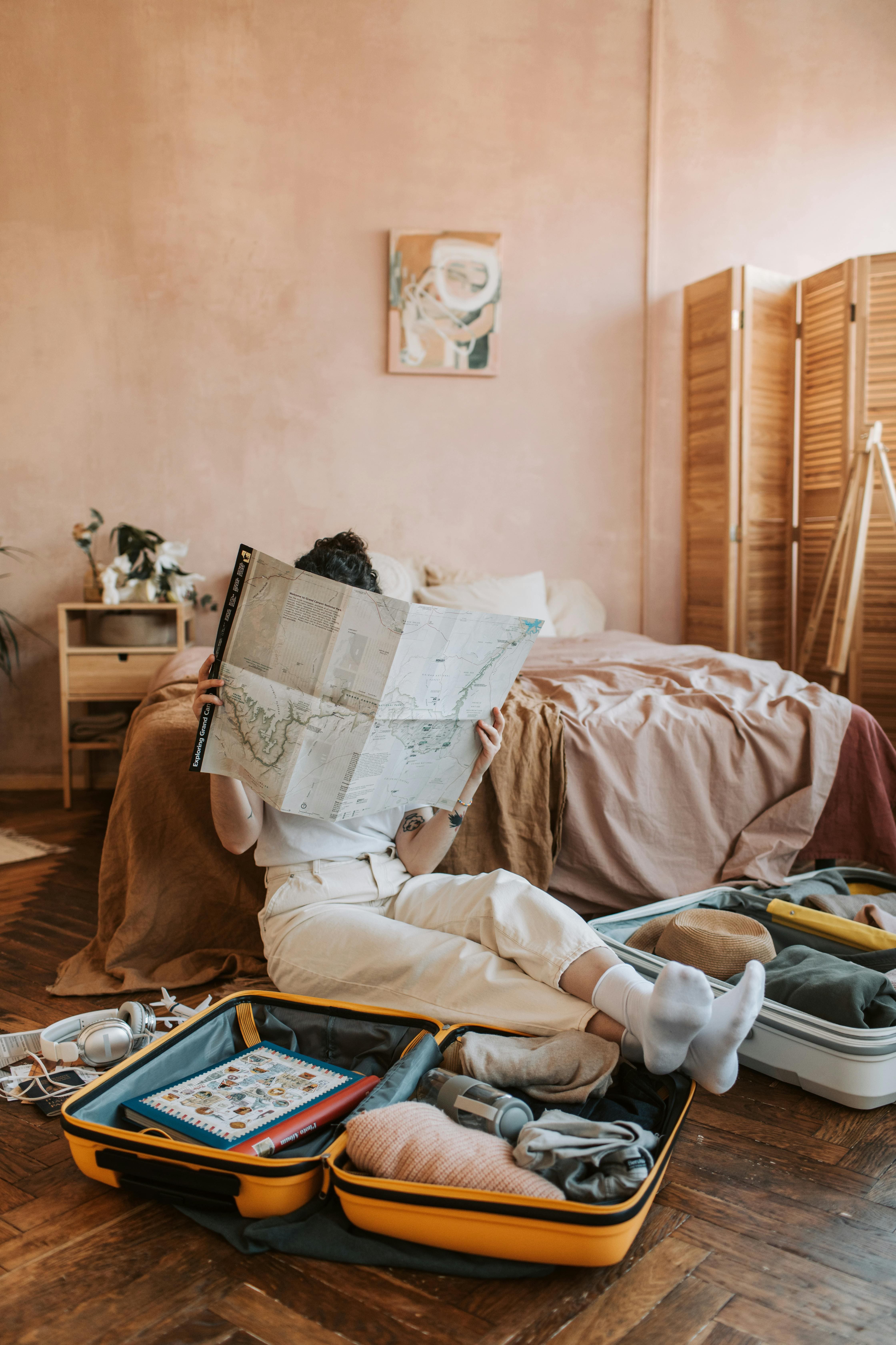 Woman thoughtfully planning transformative travel while packing, studying map for intentional trip preparation