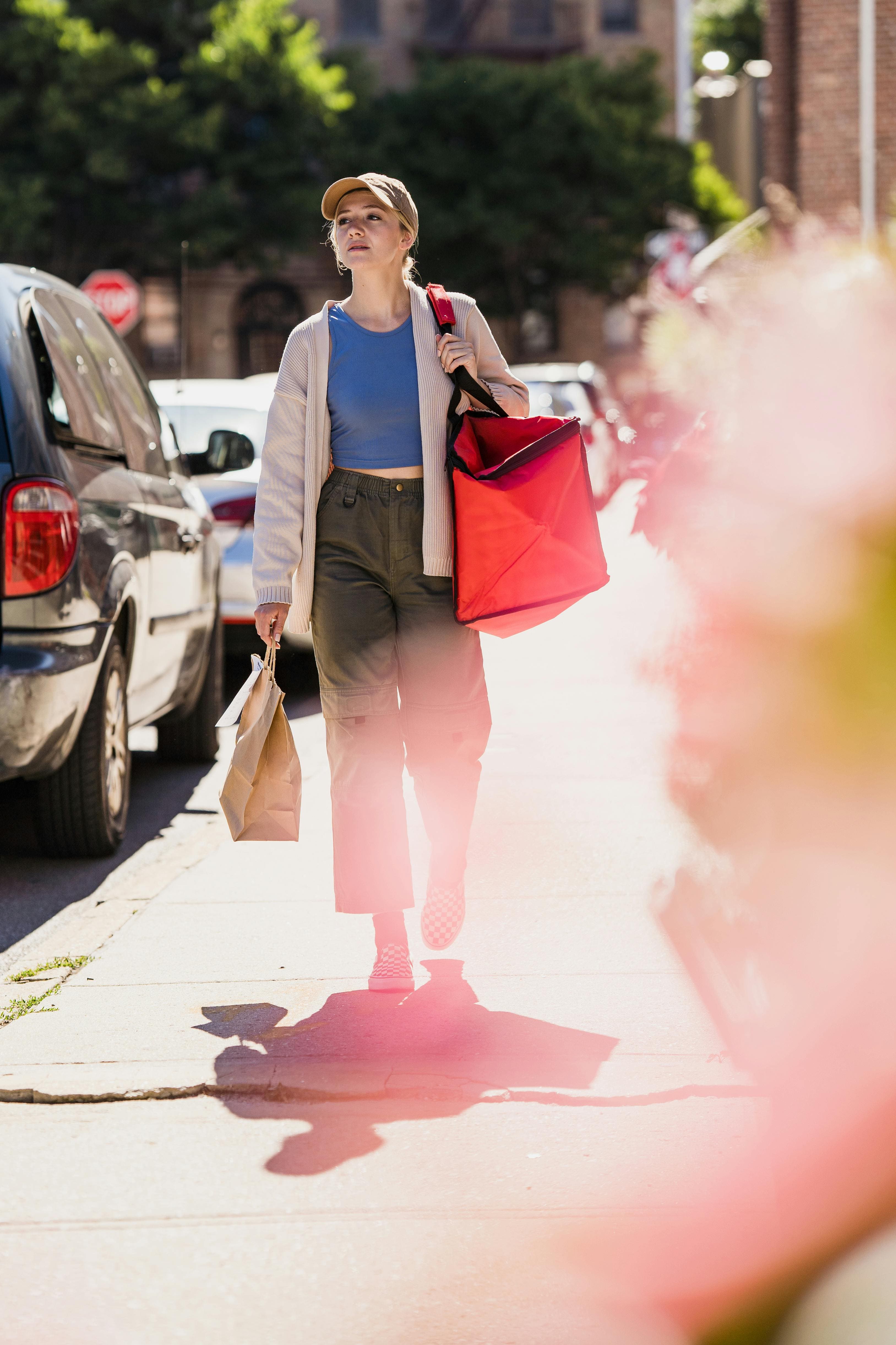 Woman walking city street with shopping bags, integrating travel transformation into daily life after coaching
