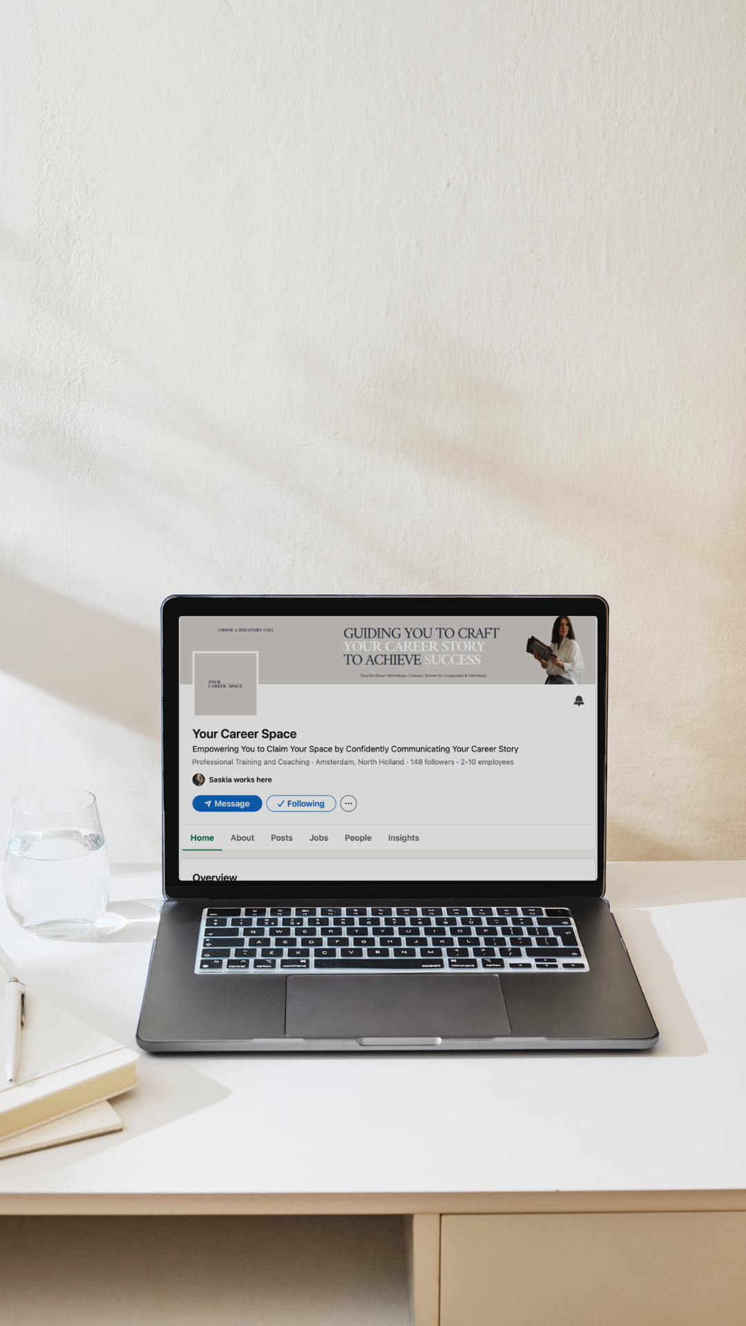 Image of a woman sitting at a round table with a coffee and taking notes