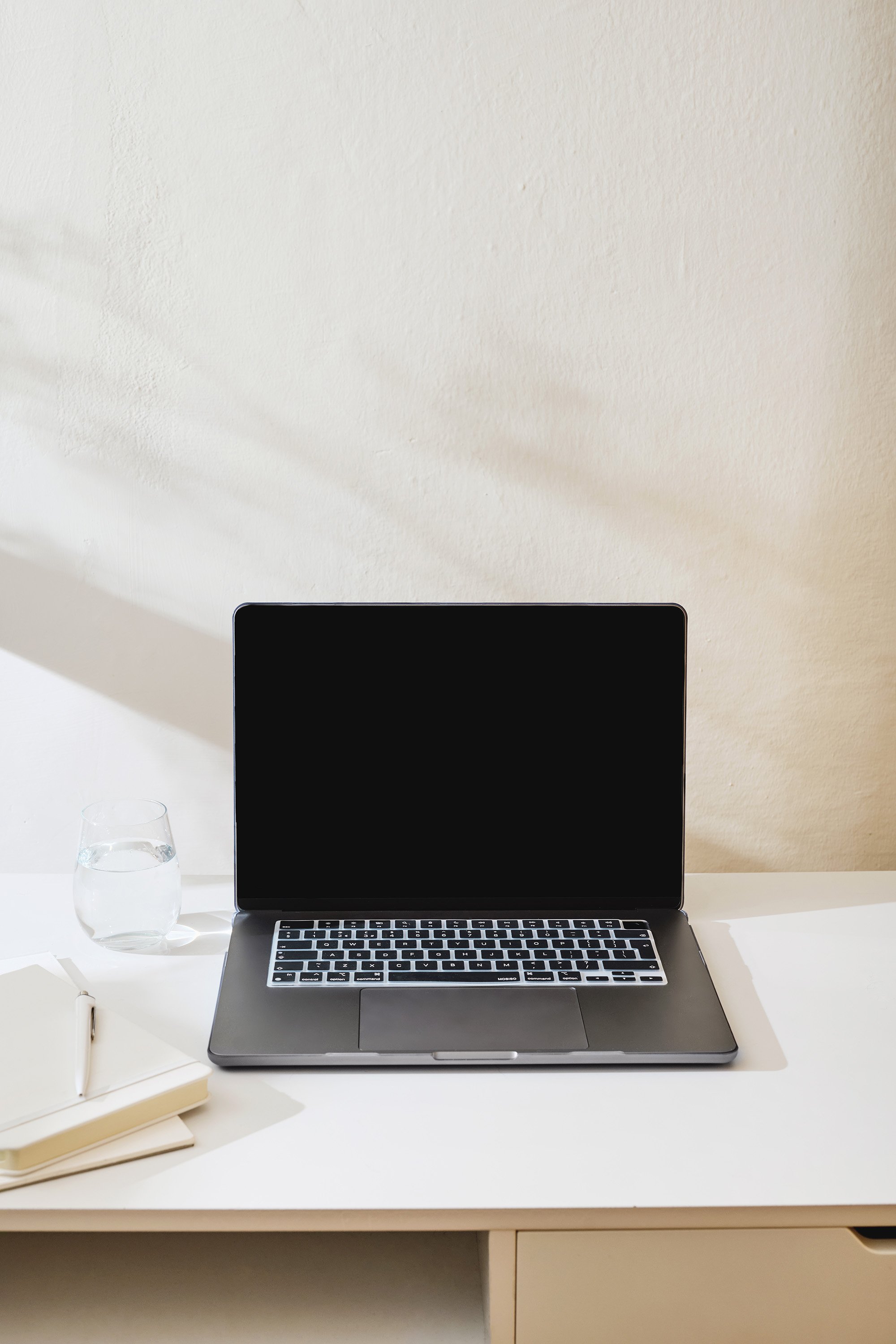 Image of a woman sitting at a round table with a coffee and taking notes