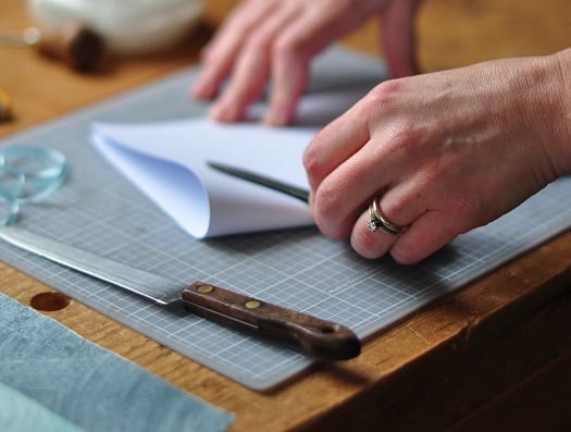 Book binder, Joelle Webber's hands as she begins an artist book project.
