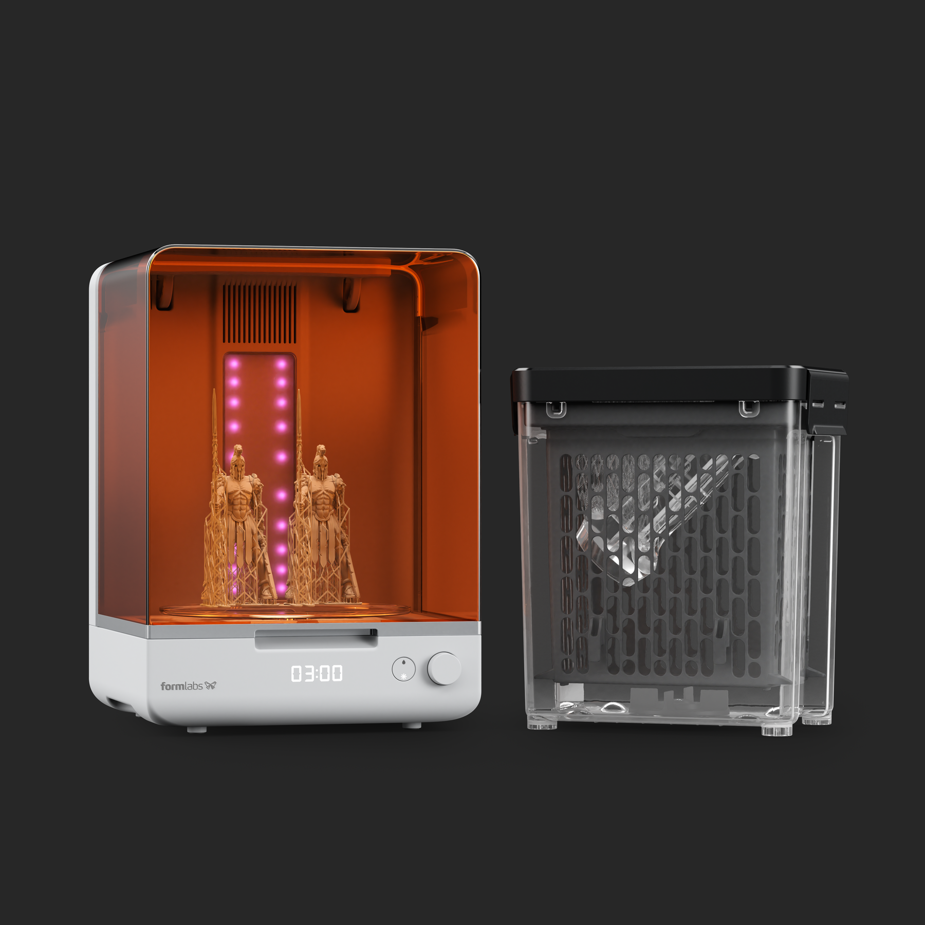 The Form Studio Cure station illuminated with IR LED's on the left with a figurine on the inside. The Form Studio Wash is on the right with a resin printed part inside of it ready to be washed.