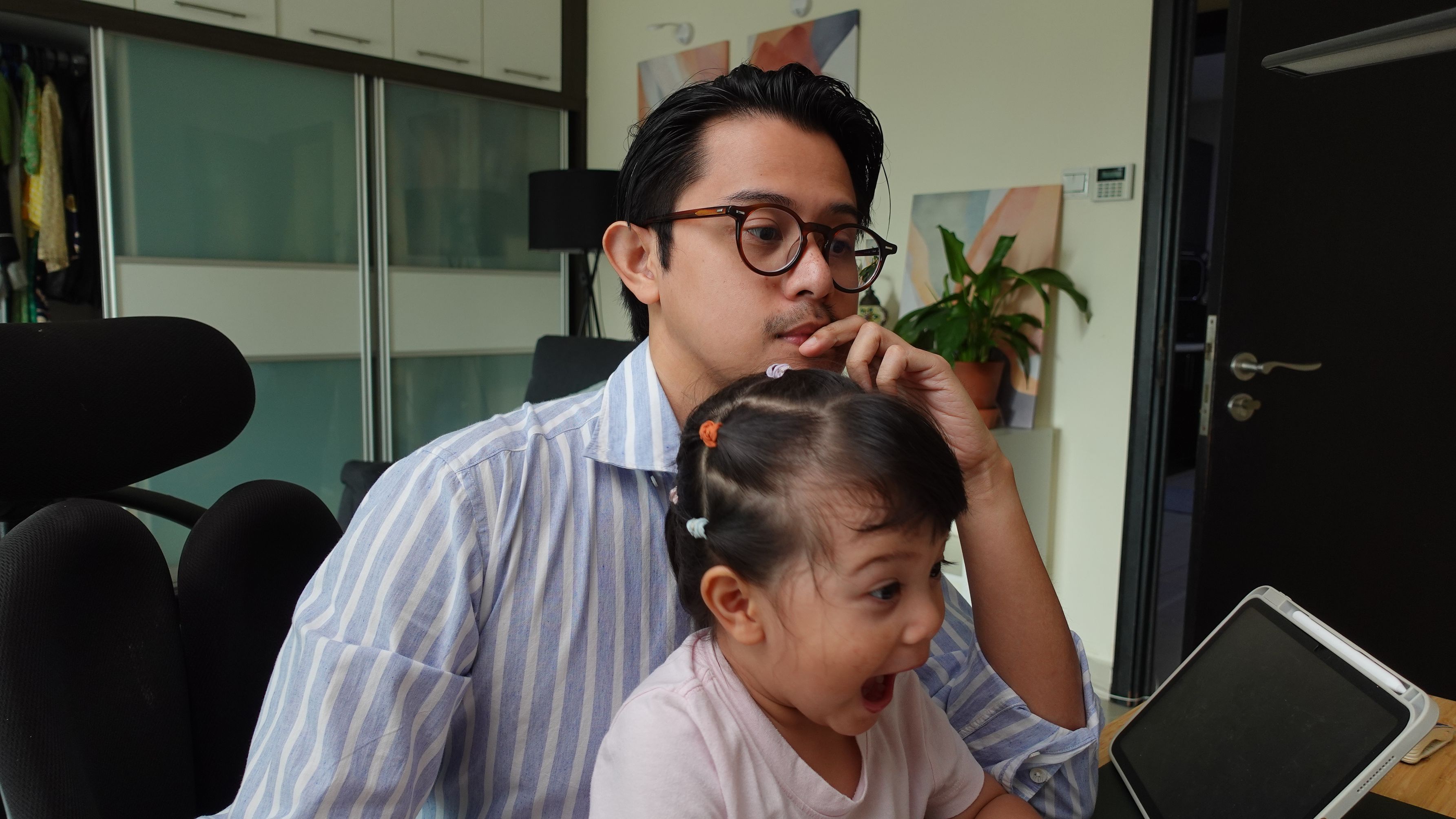 Helmi working with his daughter on his lap