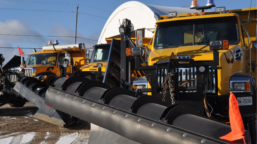 Photo of three yellow plow trucks