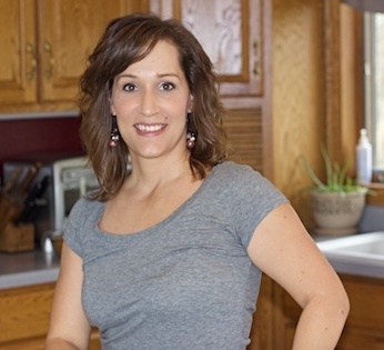 Author Paula Miller standing in kitchen with gray shirt