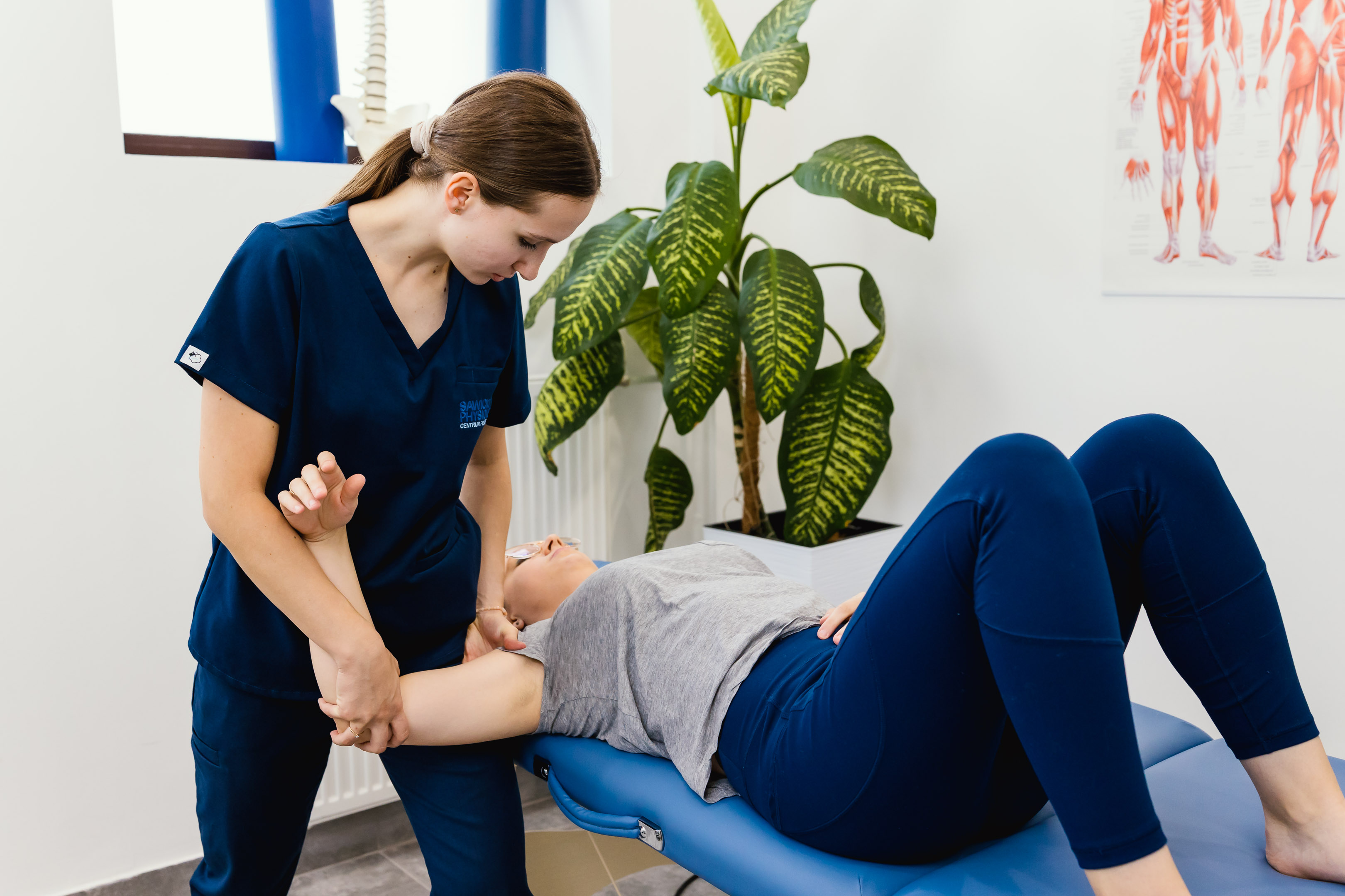 Terapia manualna ramienia i barku pacjentki prowadzona przez fizjoterapeutkę.