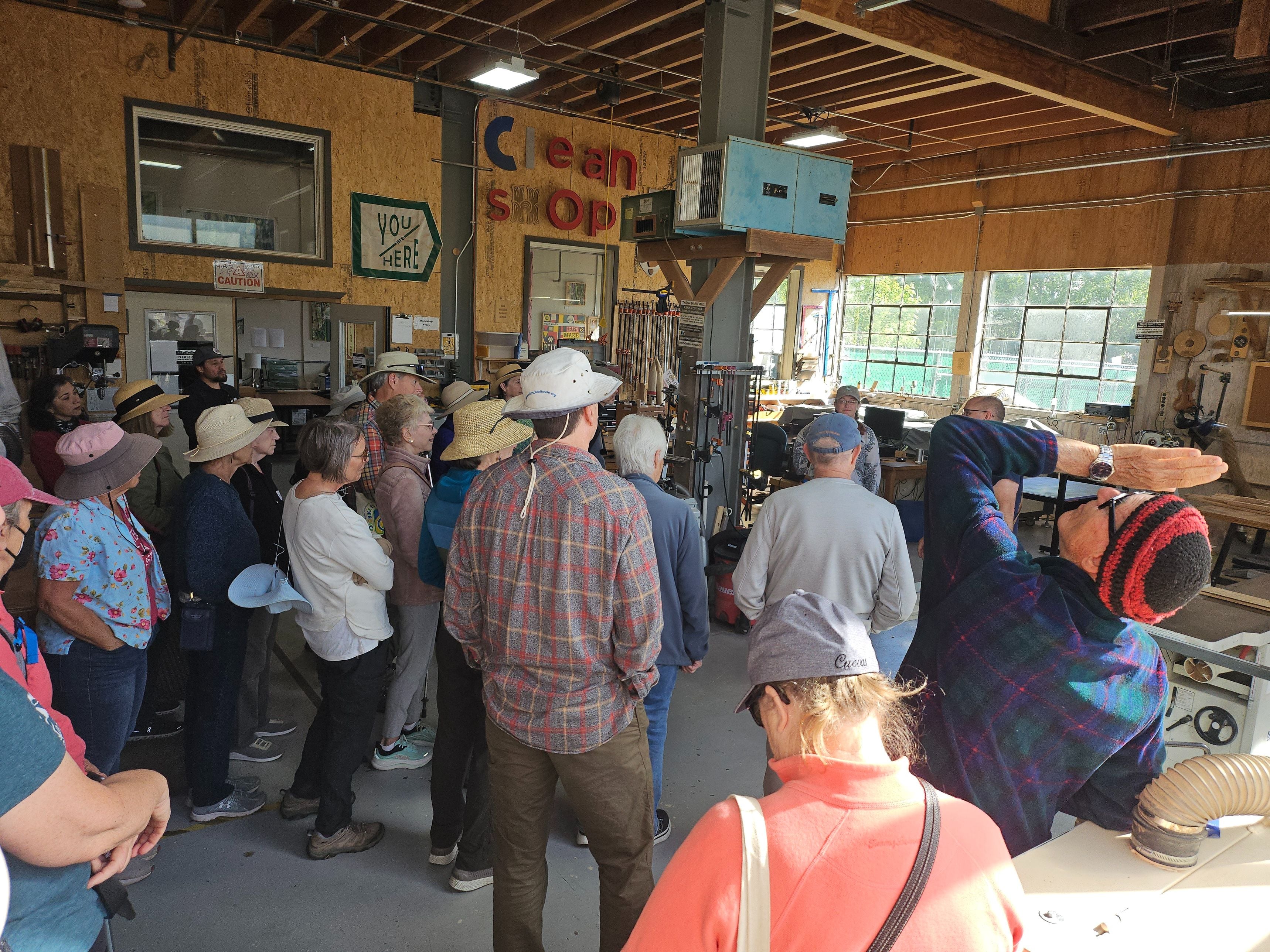 A walking group touring a community woodshop.
