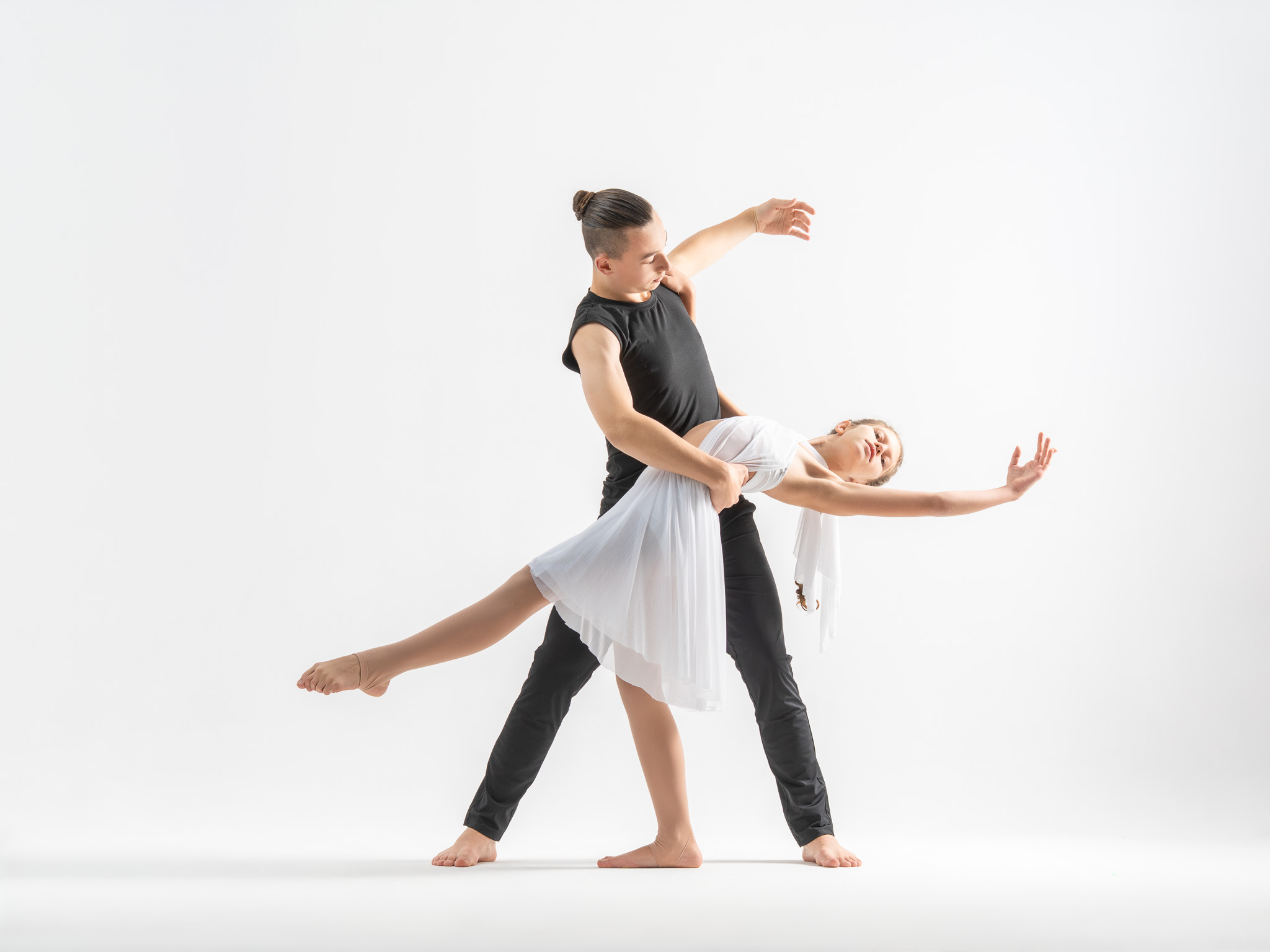 tancerka w dynamicznej akrobatycznej pozycji, pies obok – sesja taneczna w studio