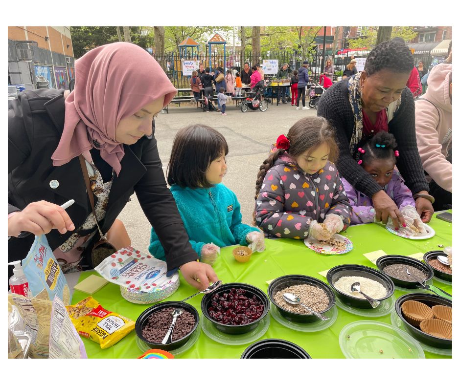 Ms. Vince leads students in making energy bites with dried fruit and seeds at Earth Day.