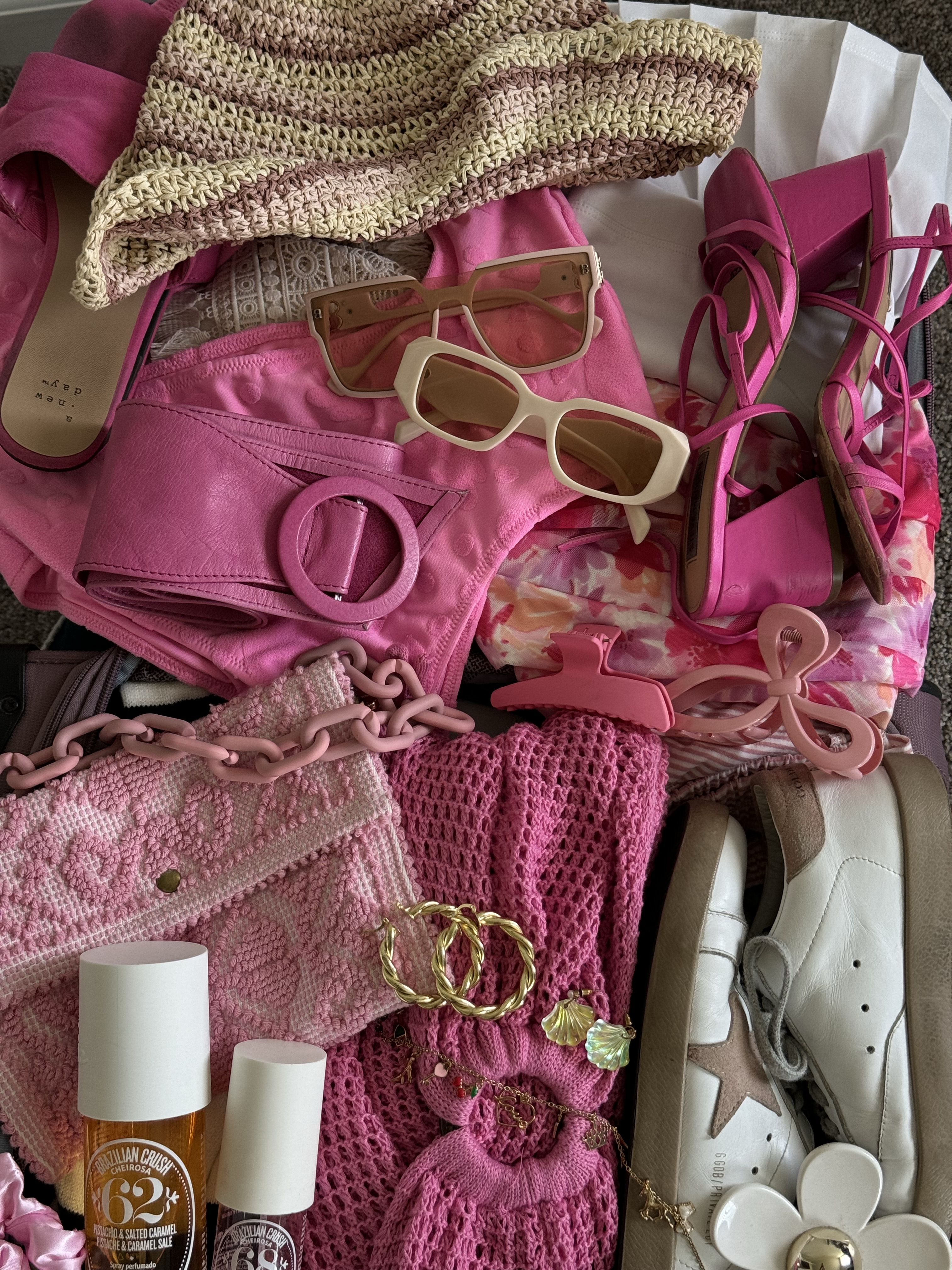 open luggage filled with pink accessories and other clothes