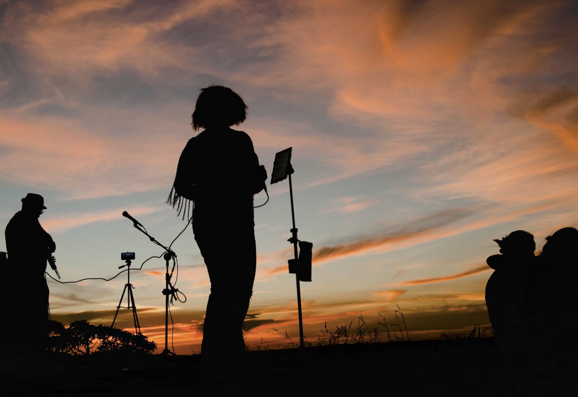 Musicians performing together at sunset