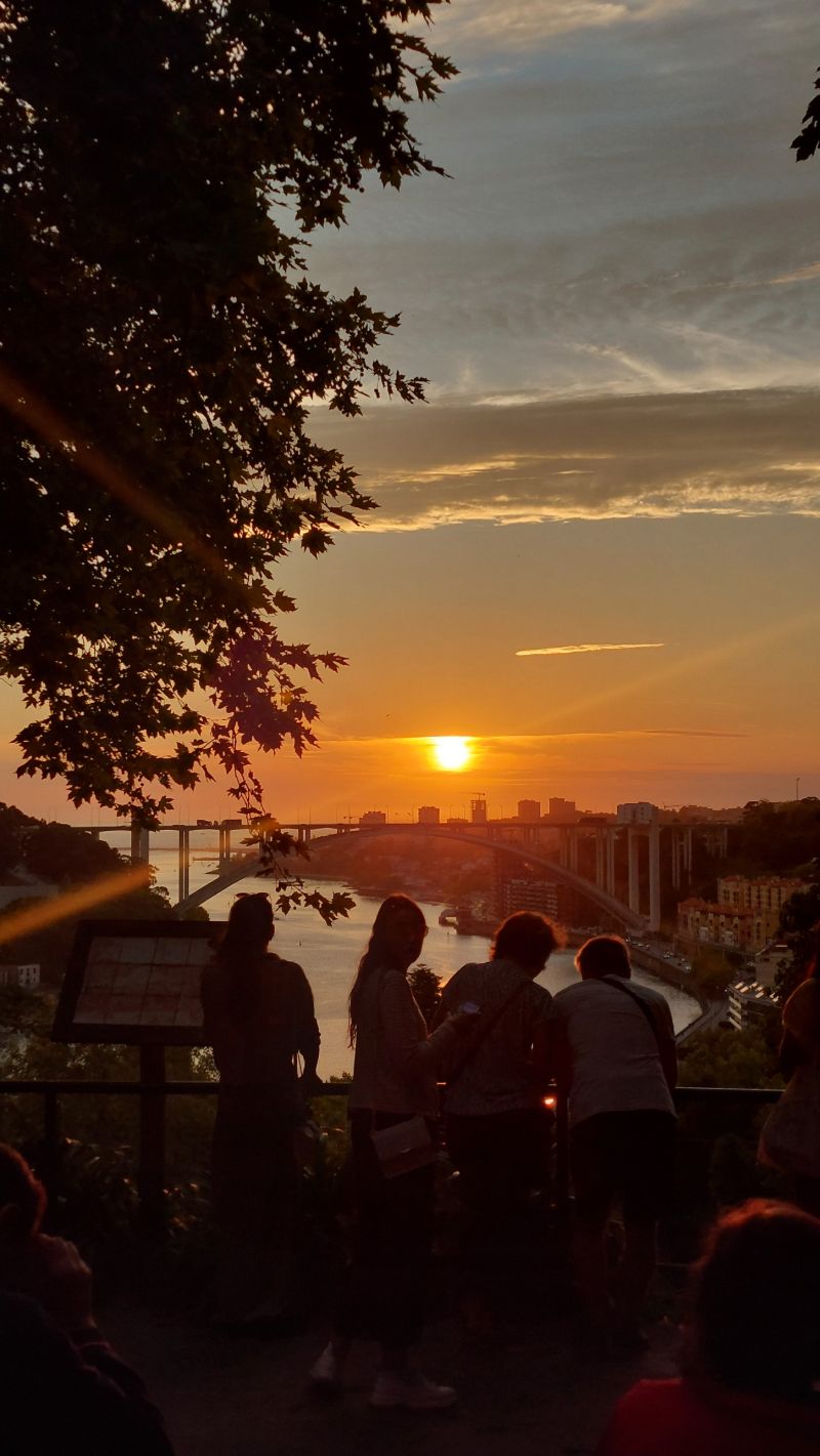 Sunset over the river with people watching from a viewpoint