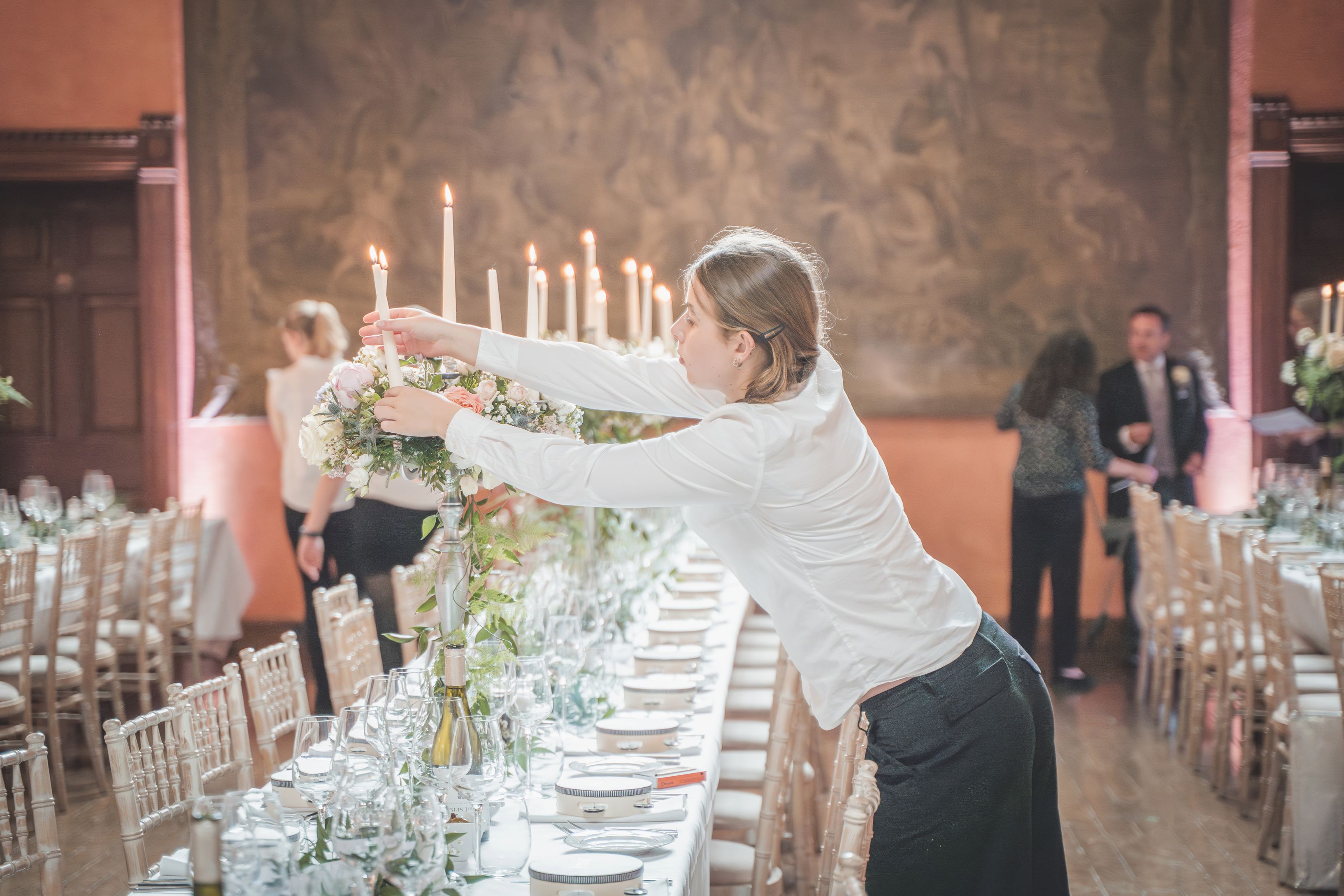 Cowdray House staff lighting the candles for the wedding banquet, storytelling photography by The Photography Boutique