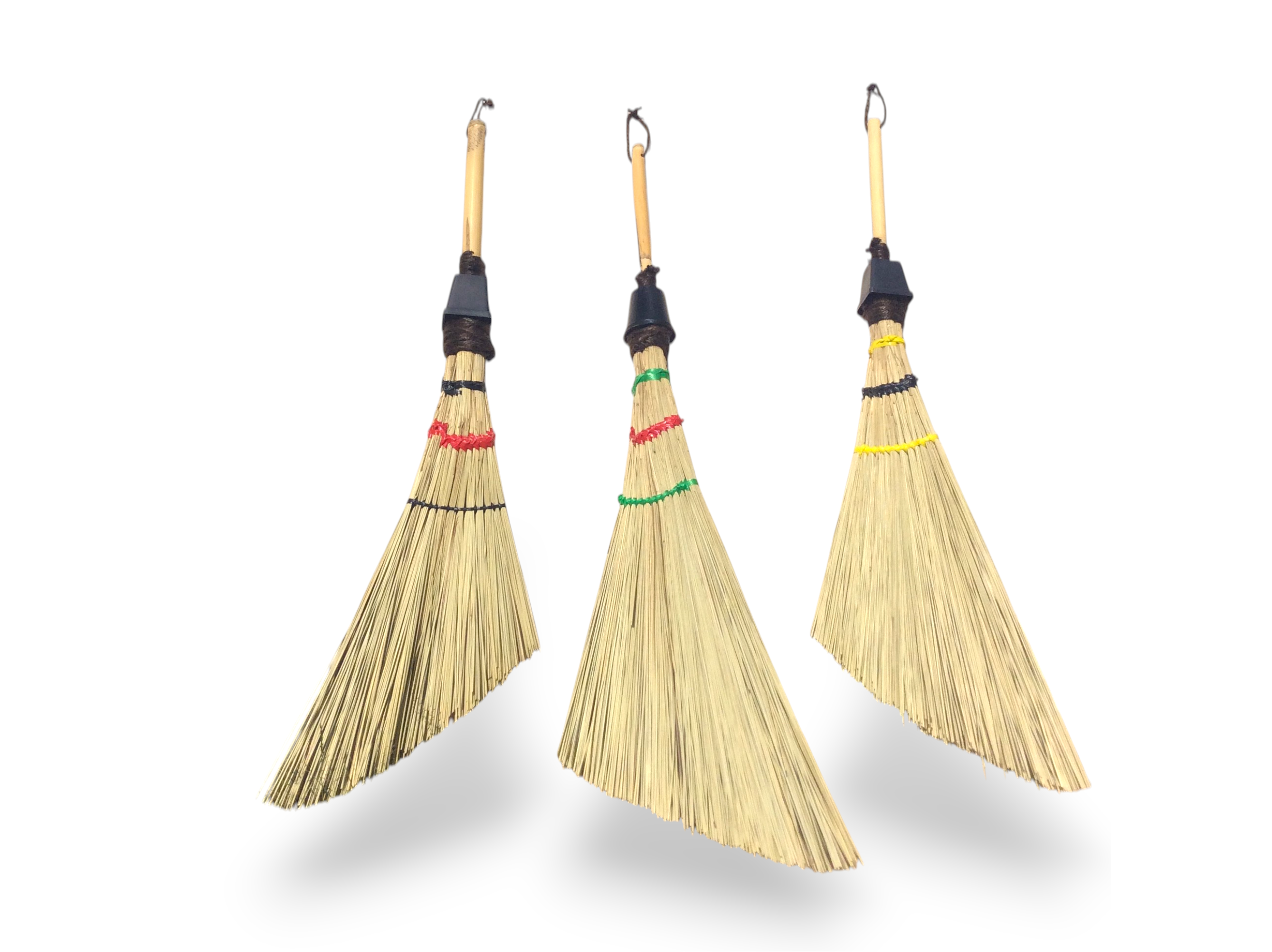A collection of three handcrafted dustpan brooms with varied colorful accents.