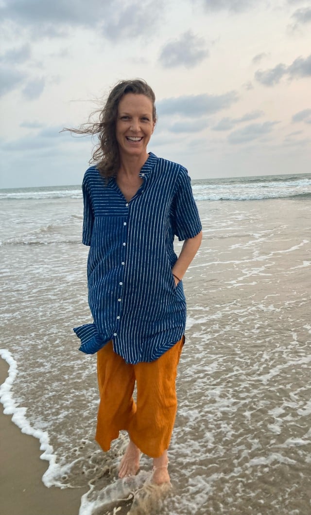 Audrey Hobbs smiling at the water's edge on a beach