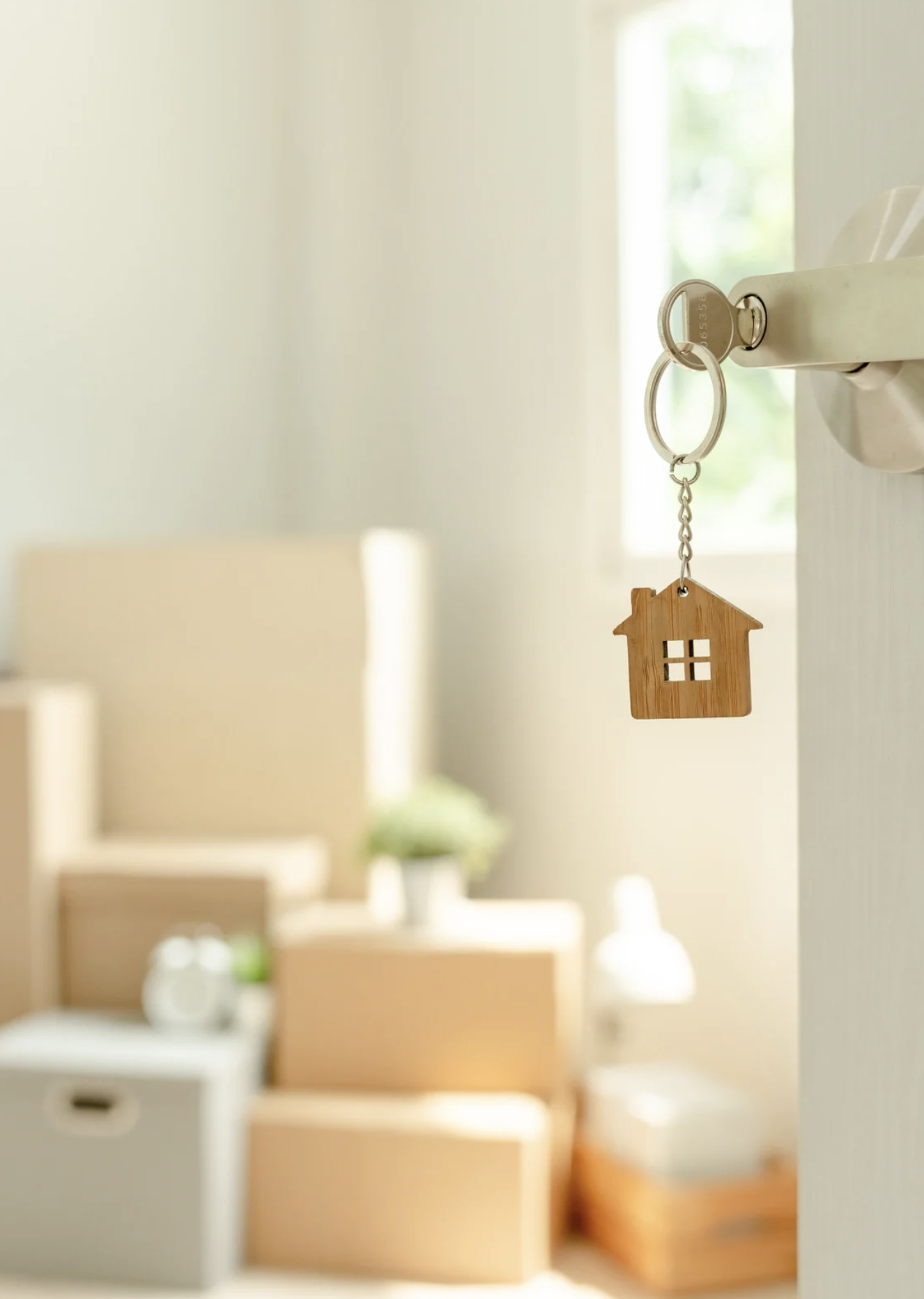House keys in a door with moving boxes in a new home