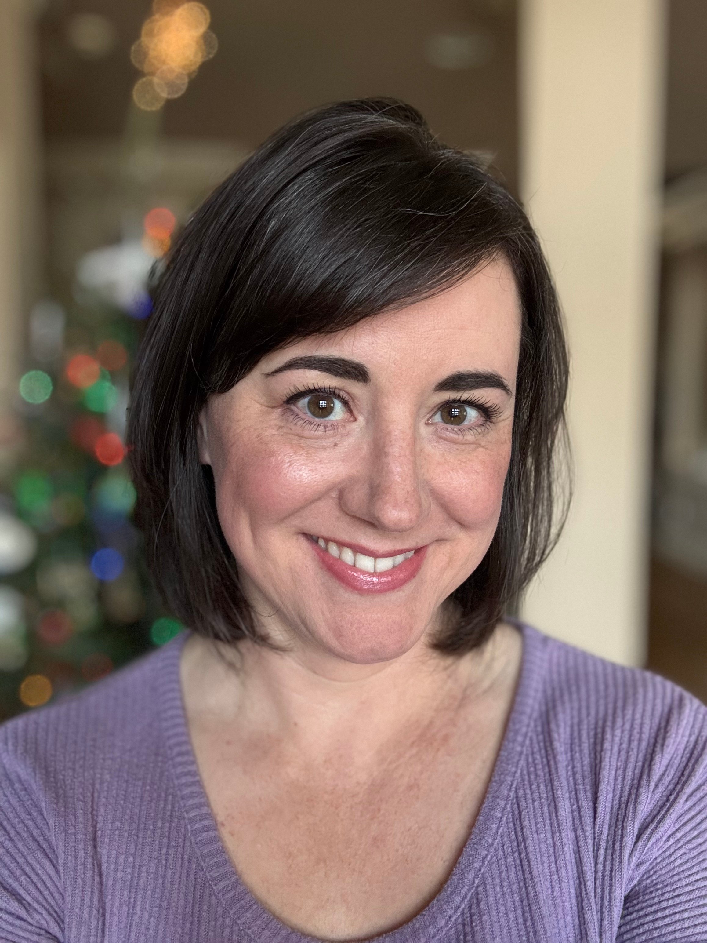 Stephanie wearing a red buffalo plaid shirt and smiling