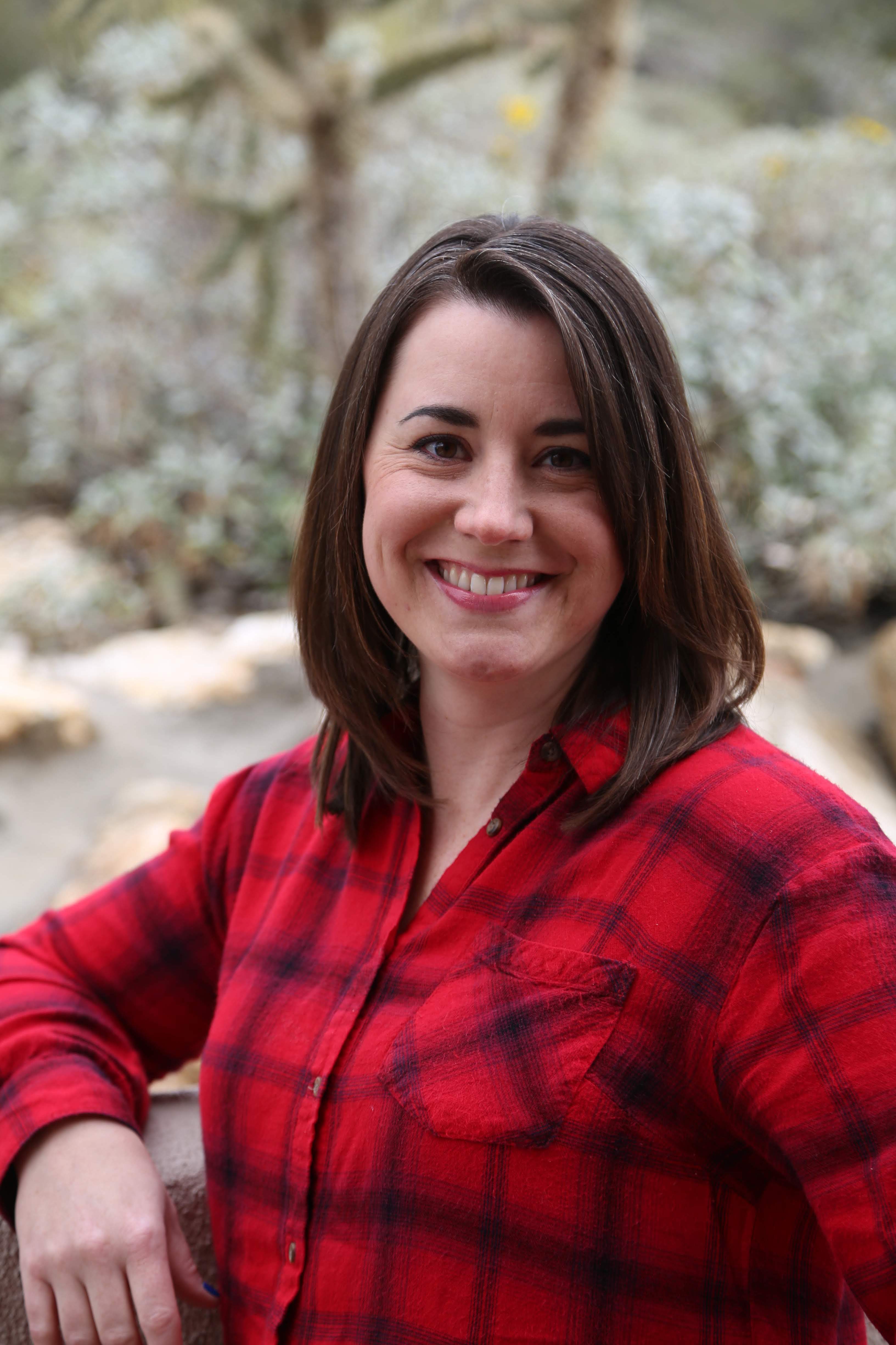 Stephanie wearing a red buffalo plaid shirt and smiling