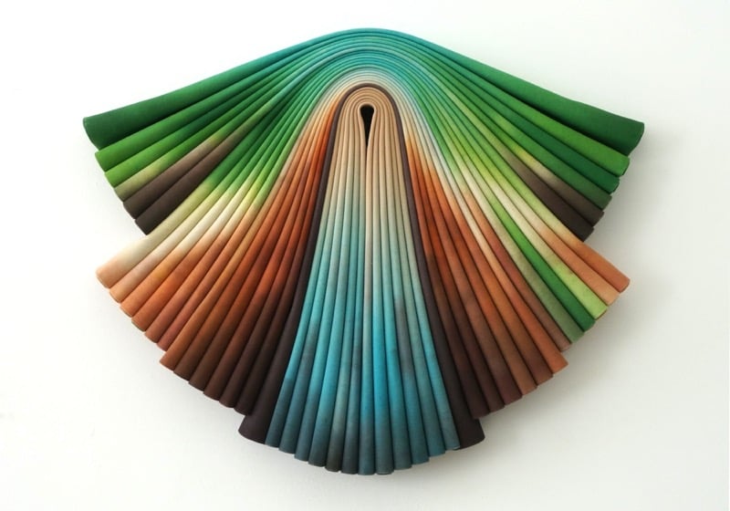 a painting on canvas folded and creased to create an elegant, colorful wall sculpture