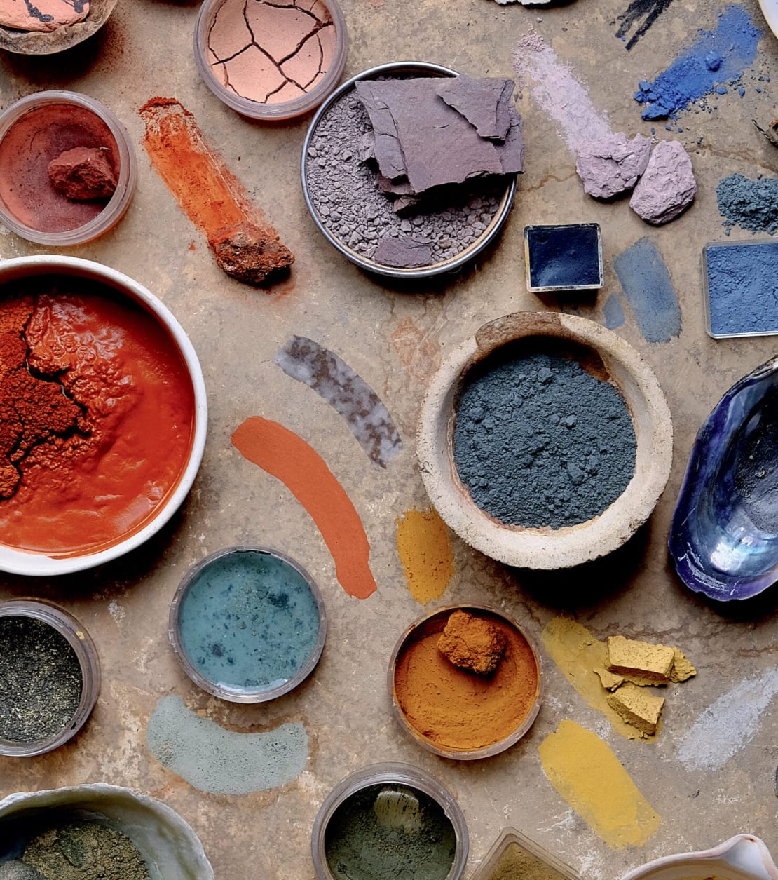 colorful pigments in dishes and piles on a surface