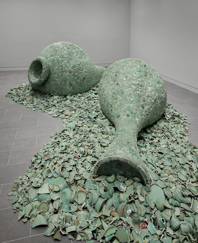 two large vessels on the floor of mosaiced celadon fragments that cloak the forms and spill out into a pool