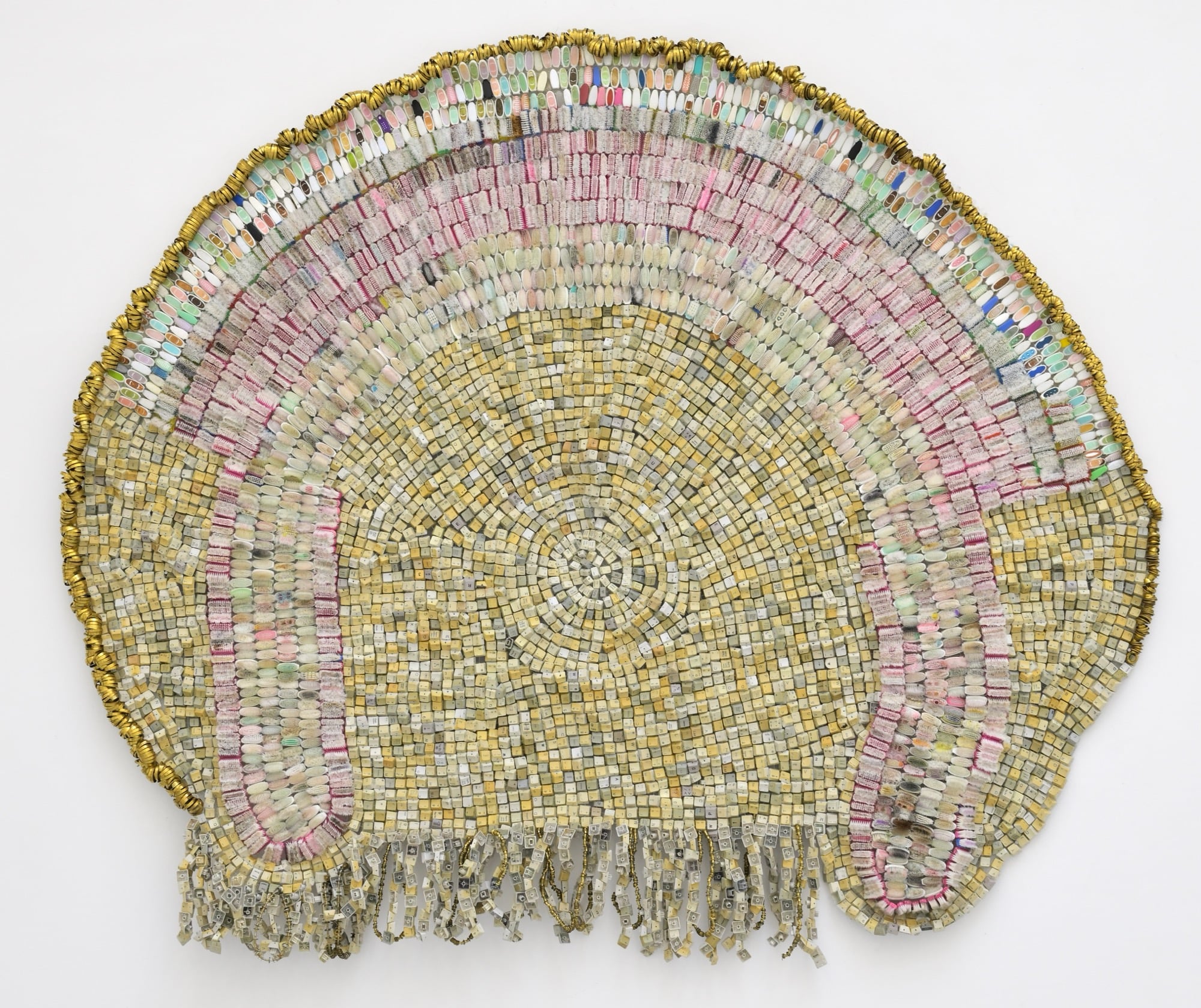 an abstract wall-installed artwork by Moffatt Takadiwa made from computer keyboard keys, combs, toothbrush heads, and metal pieces