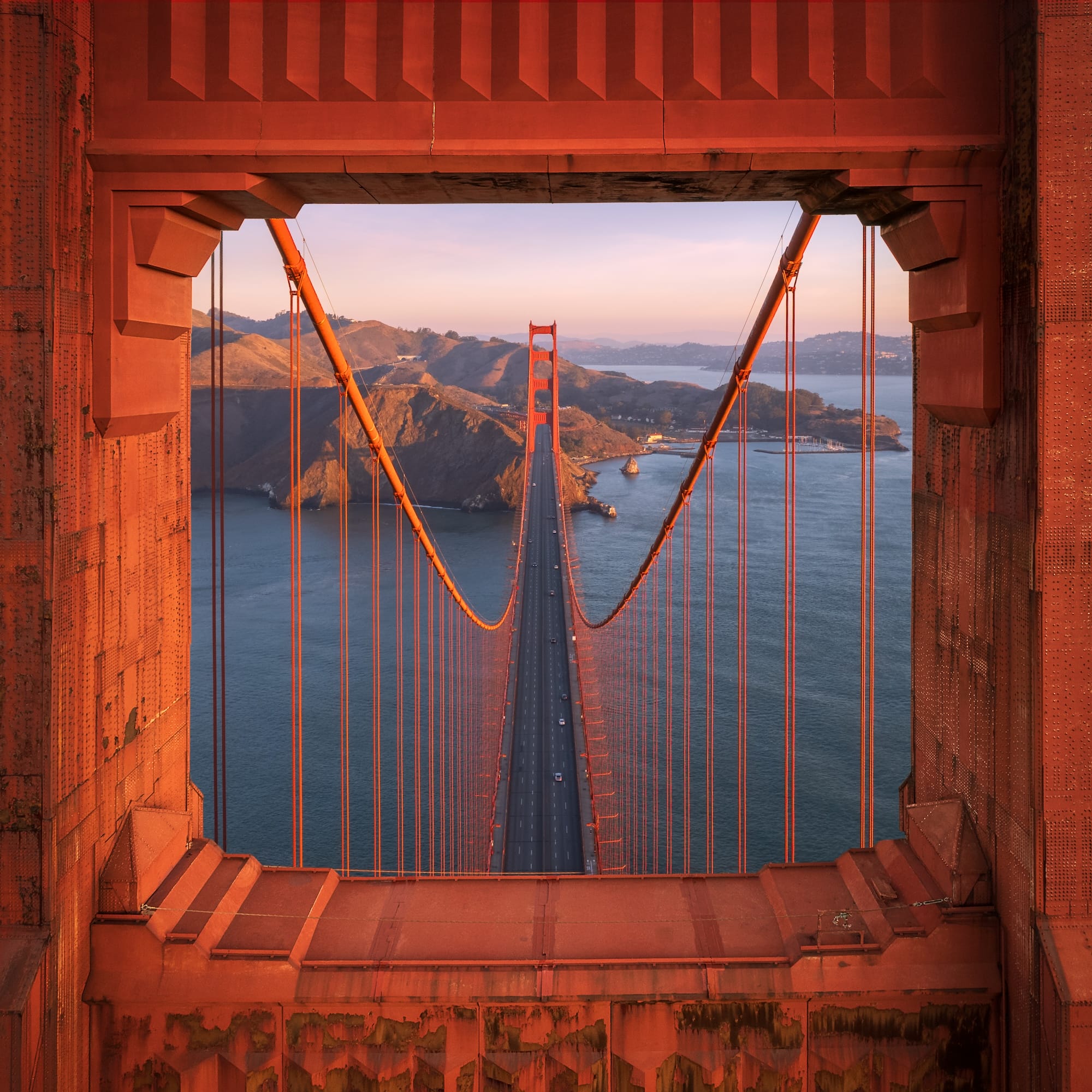 an aerial photograph of the Golden Gate Bridge in San Francisco framed through one of its tower's openings