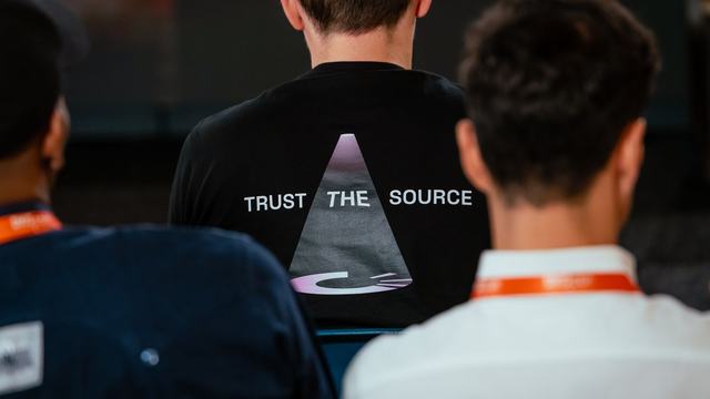 DKGcon attendee wearing a Trust the Source shirt
