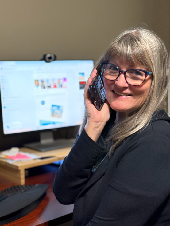 Laura Varnau sitting at her desk talking on the phone.