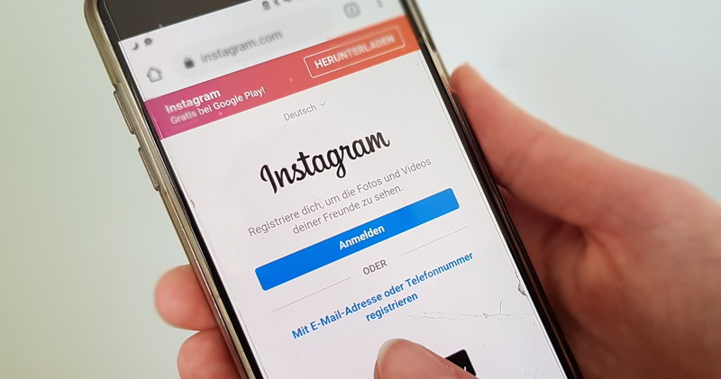 Smartphone mit der Instagram-Anmeldemaske liegt in der Hand