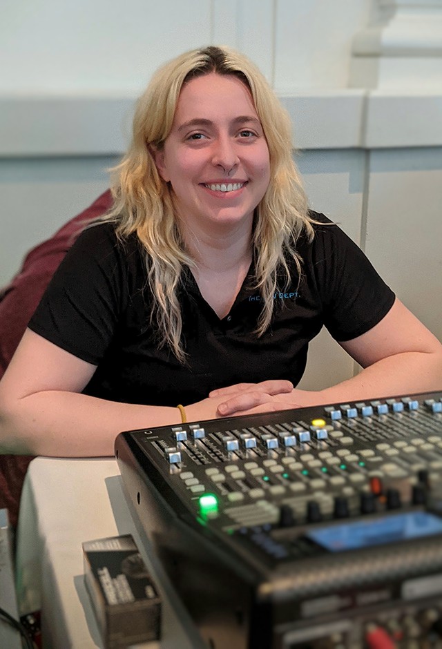 Heidi Christiansen, Audiovisual Technician, sits at an audio mixing console