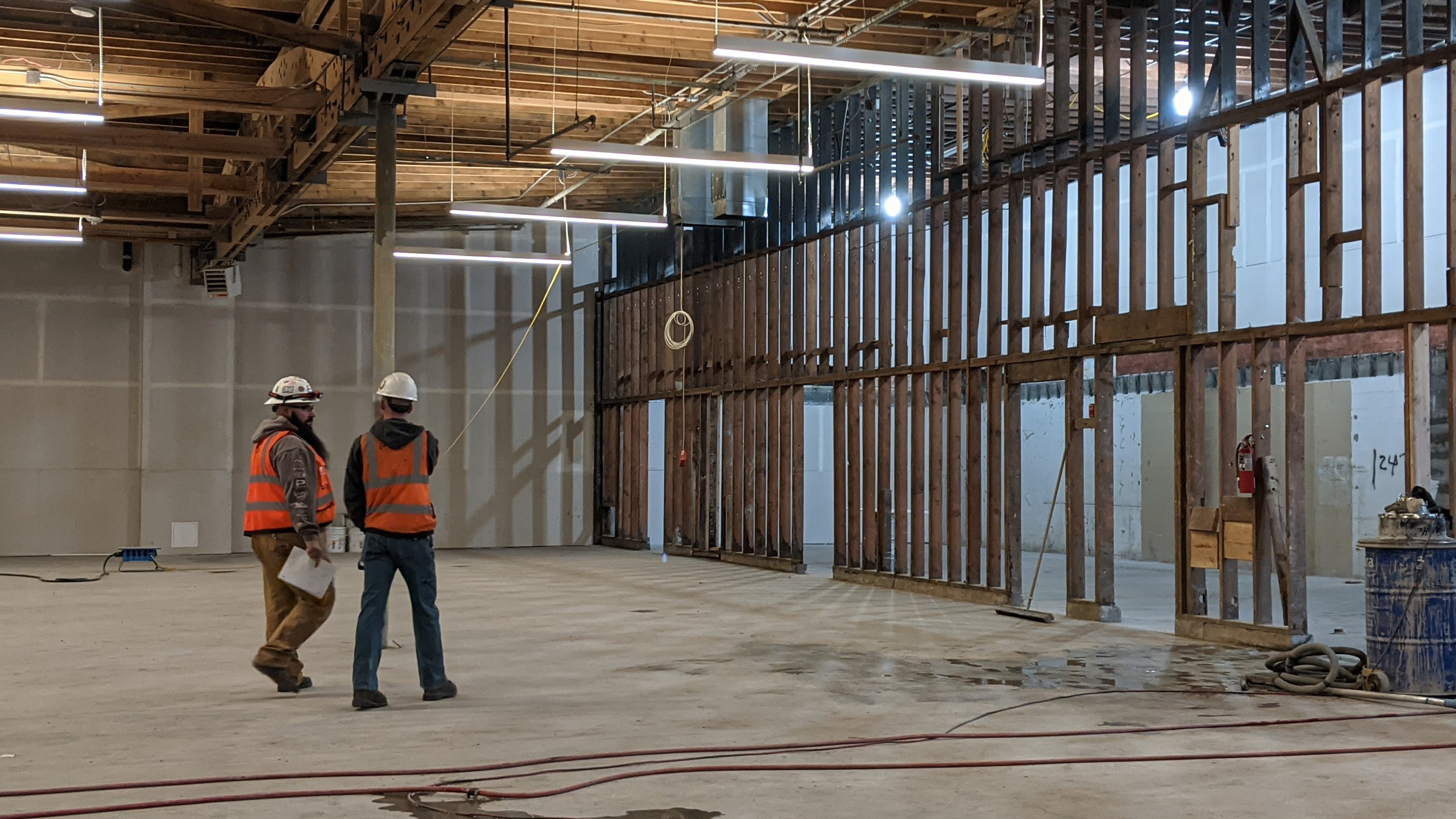 Two consruction works walk across the interior of AVENUE as the build out begins.