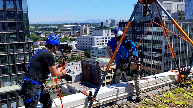 A videographer captures the action as a participate prepares to rappel down the side of a 15 story building as part of a fundraising event