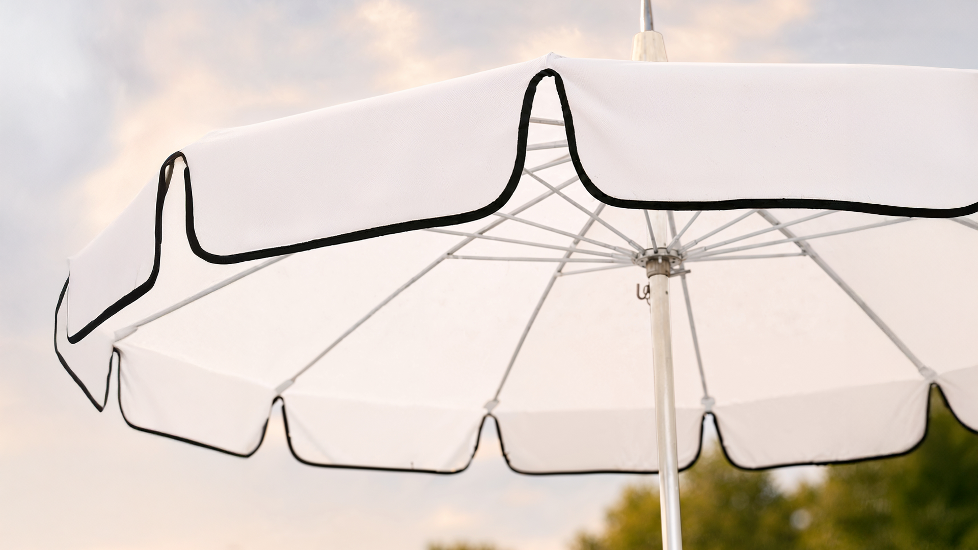 Close-up of a California Umbrella Pagoda canopy with Sunbrella fabric, black trim, scalloped valance, and frame details.
