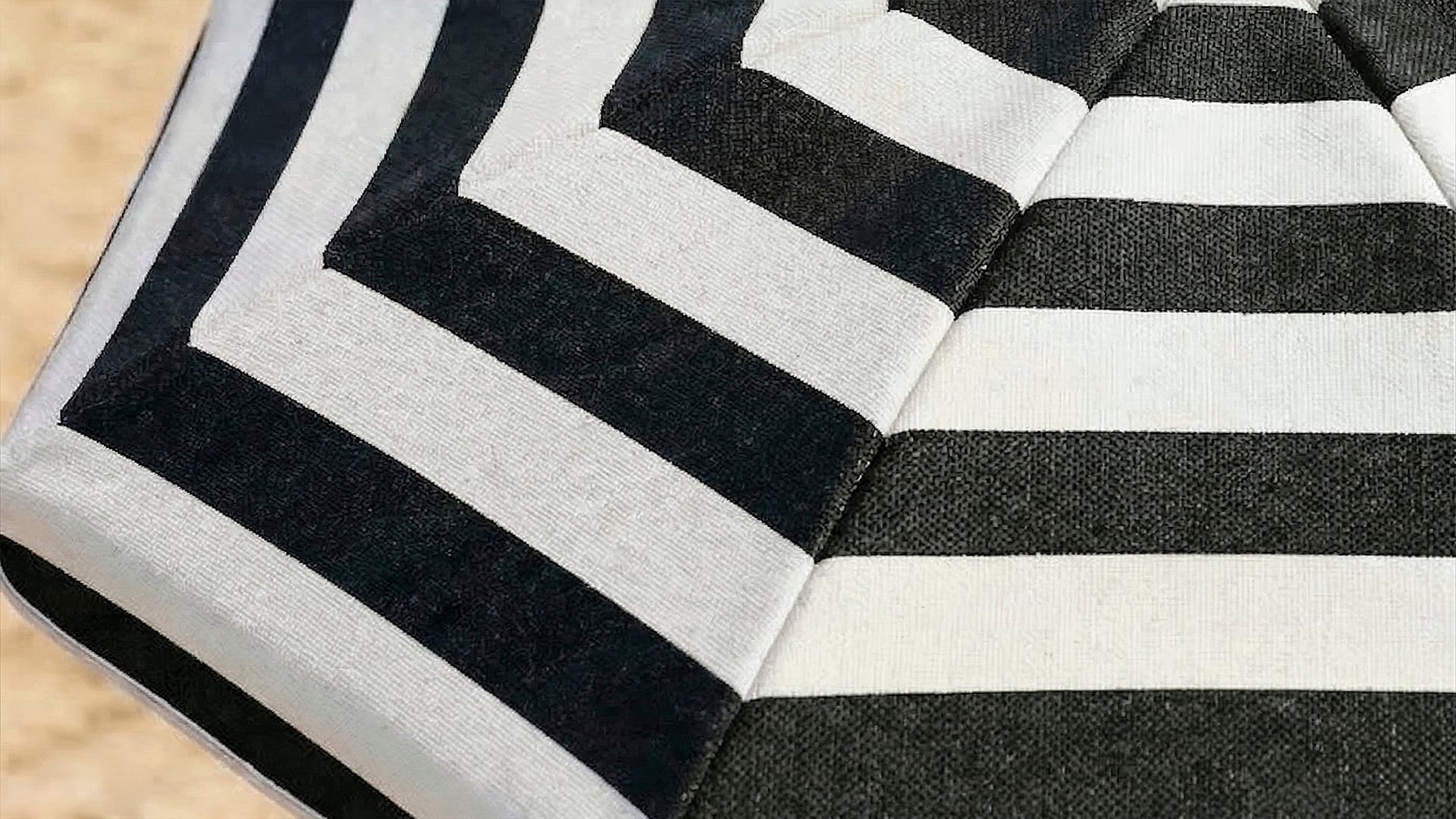 Close-up of black and white striped California Umbrella patio umbrella fabric, highlighting bold pattern and canopy detail.