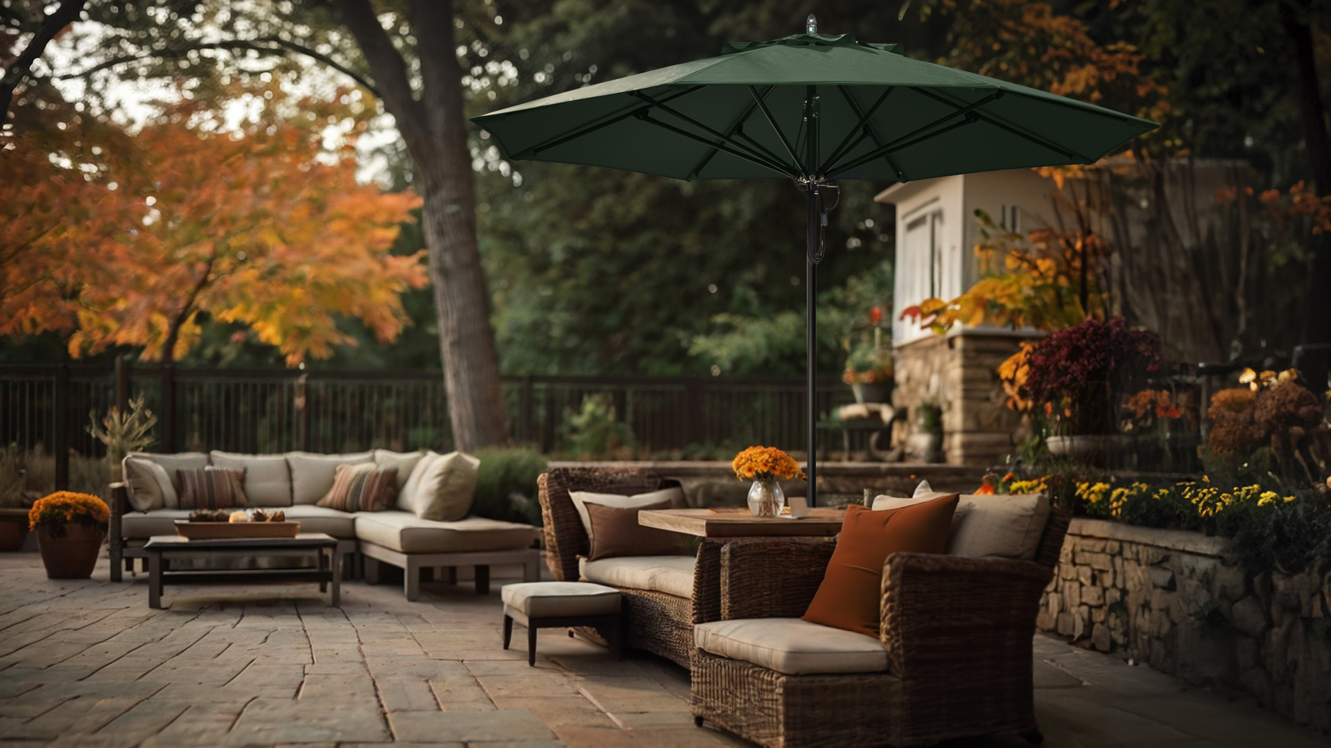 A serene fall patio setup featuring a Newport Series Commercial Grade Patio Umbrella with a Sunbrella Forest Green canopy, providing ample shade over a cozy outdoor seating area with wicker furniture, autumnal flowers, and a rustic stone patio.