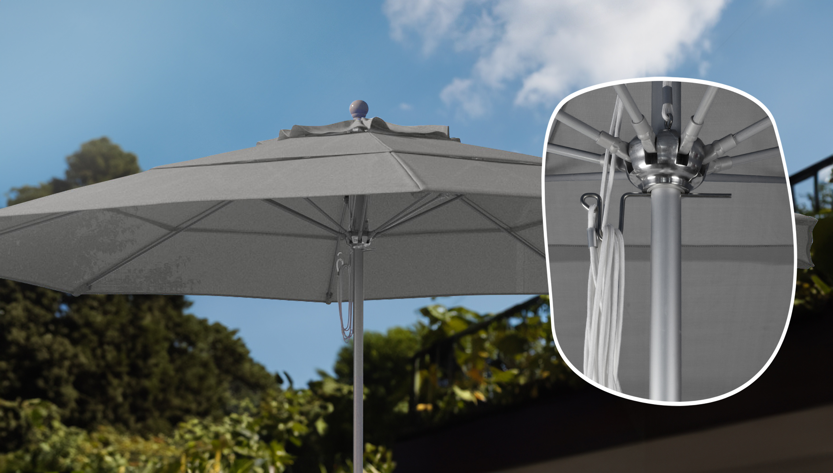 Close-up of the California Umbrella Venture Series patio umbrella, showcasing the durable aluminum hub and easy-to-use pulley system under a gray Sunbrella canopy.