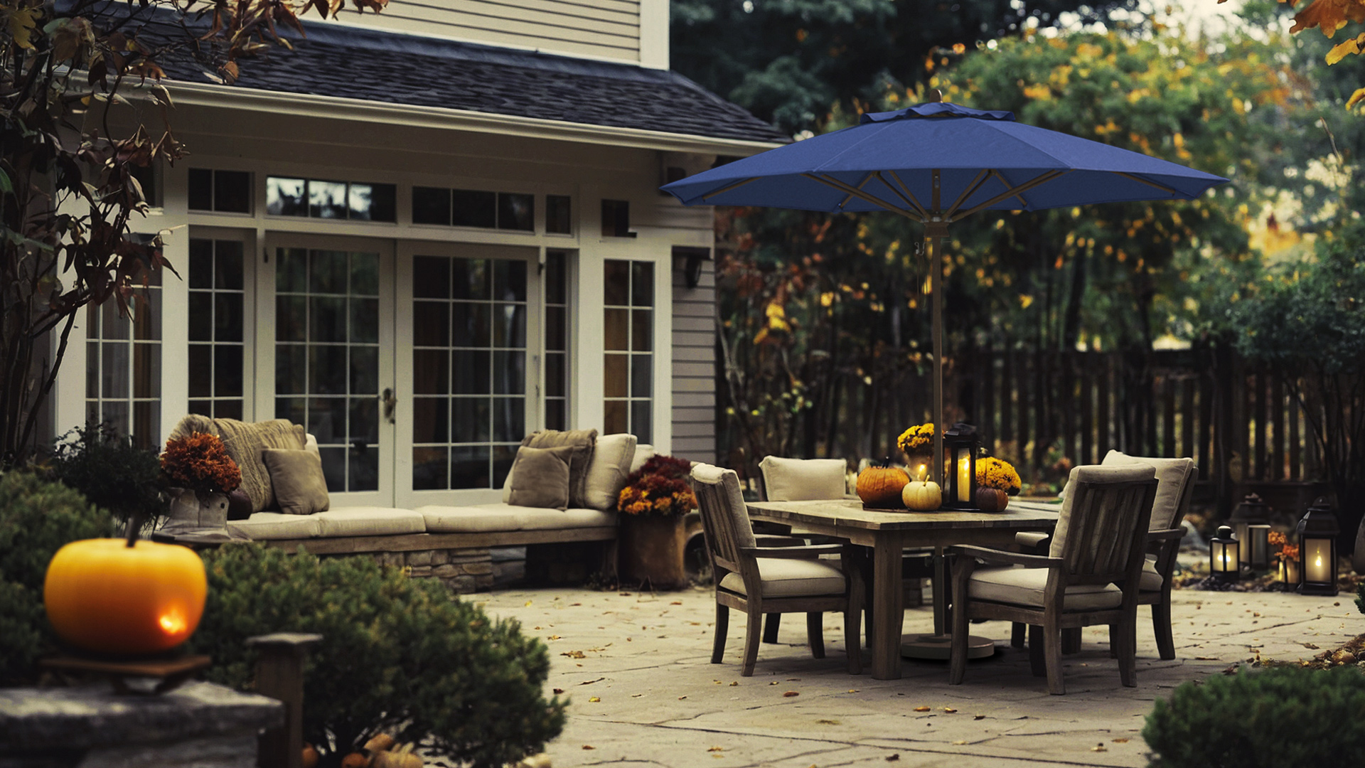 Cozy autumn patio scene featuring the Madera Series umbrella by California Umbrella with a Sunbrella Pacific Blue cCozy autumn patio anopy, creating a warm and inviting outdoor space for fall entertaining.