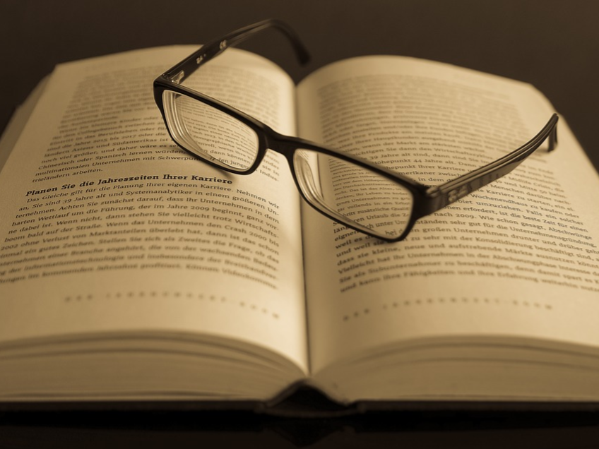 Eye glasses resting on an open bookl