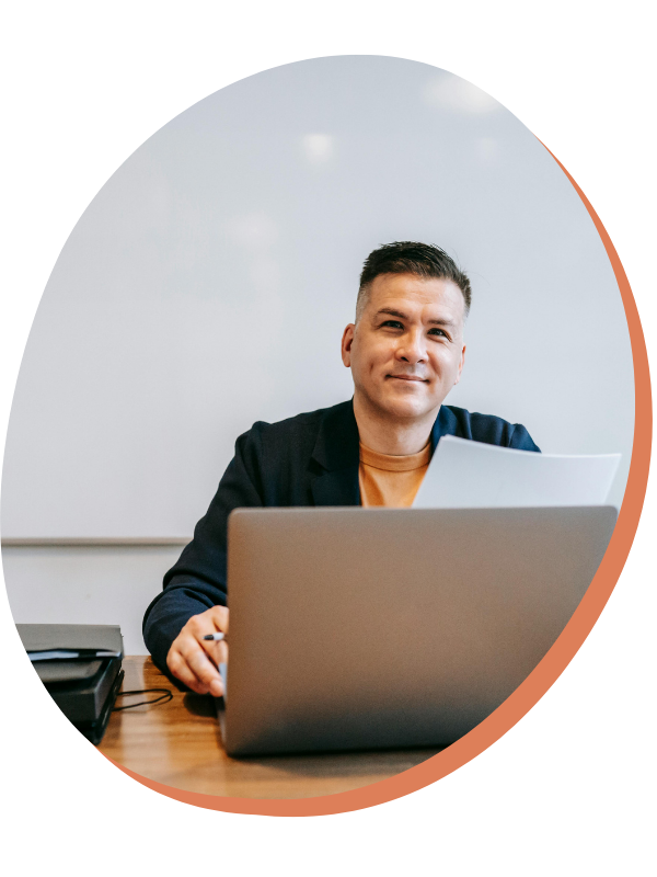 Woman with braids working on her phone with laptop in front - dream catch consulting