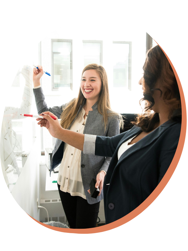 Woman with braids working on her phone with laptop in front - dream catch consulting